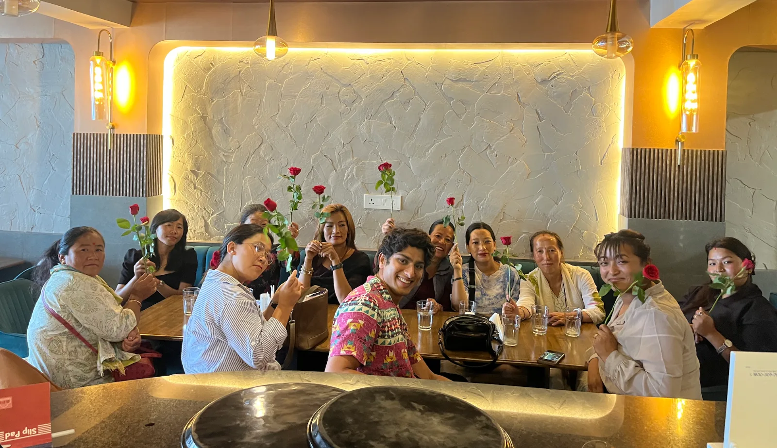 The didis of Yakten around a cafe table, each holding a rose