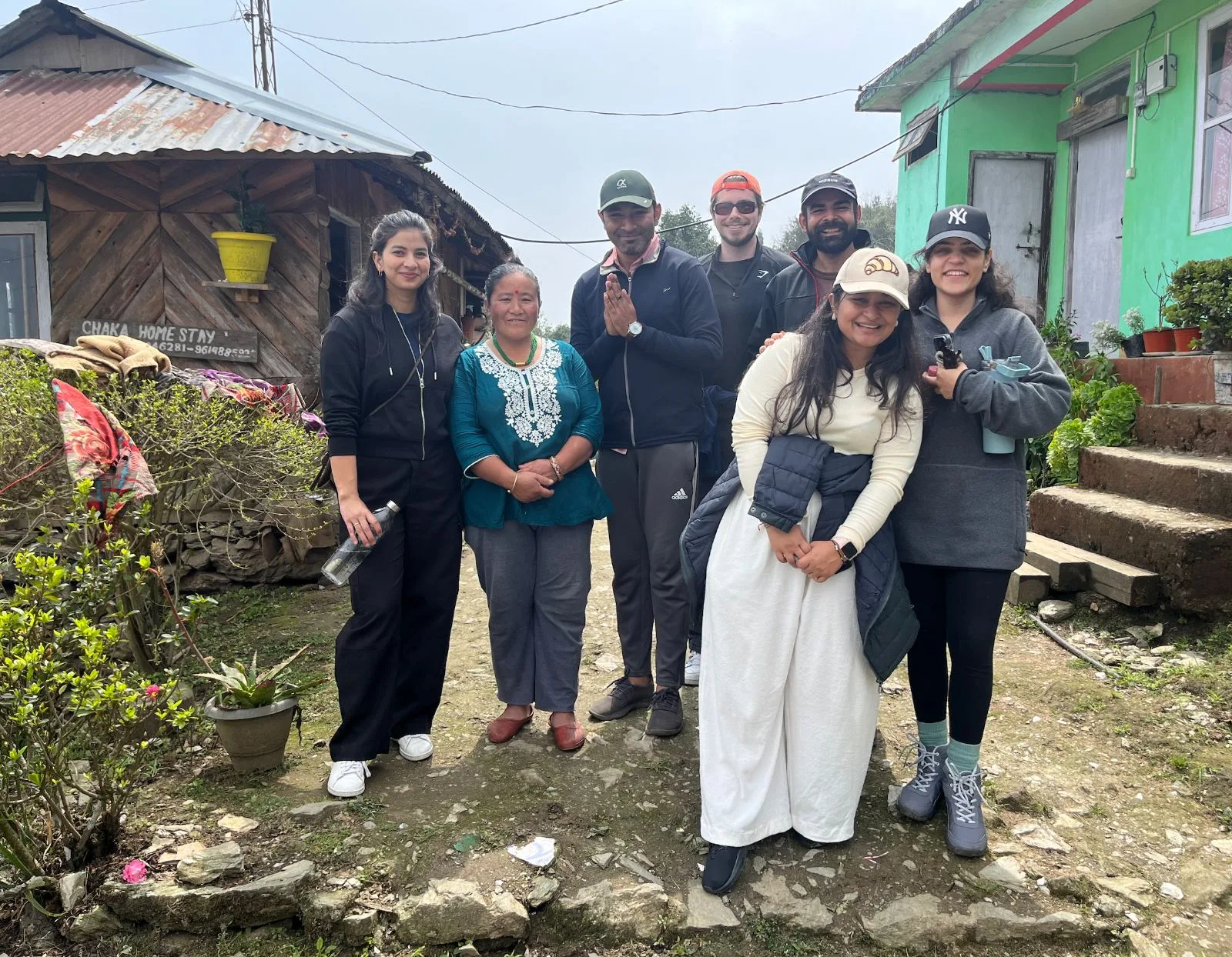 Guests and their host outside a homestay in Yakten