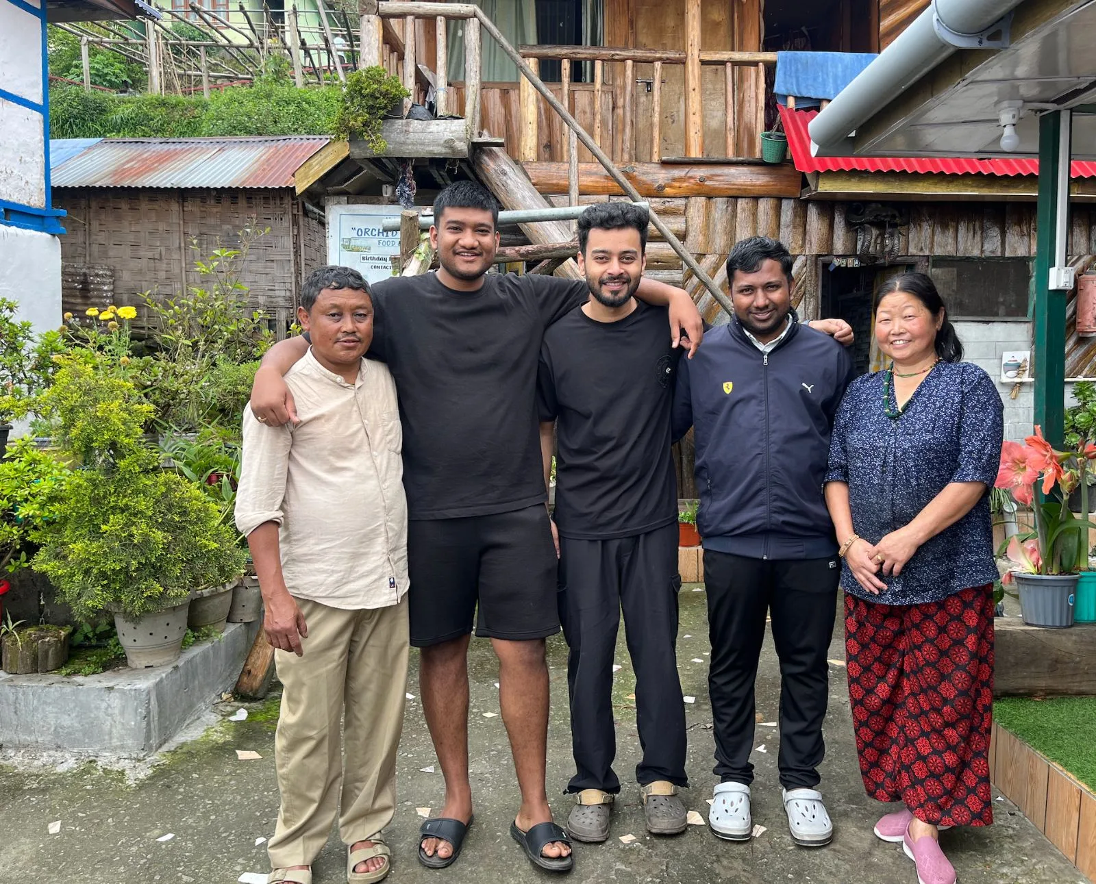 Guests with their host family in the courtyard of Orchid homestay, arms around each other